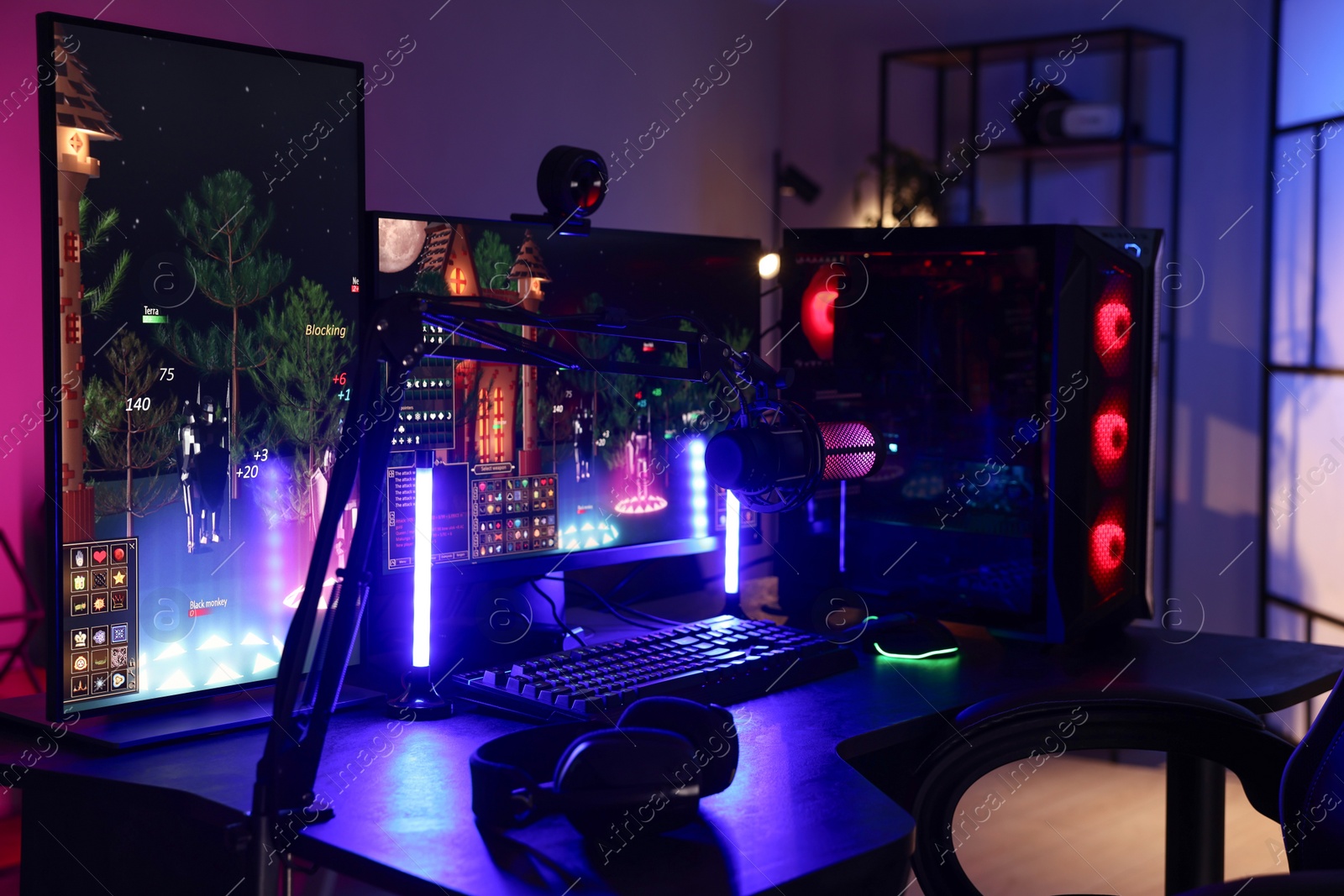 Photo of Playing video games. Stylish room interior with modern computer and gaming chair in neon lights