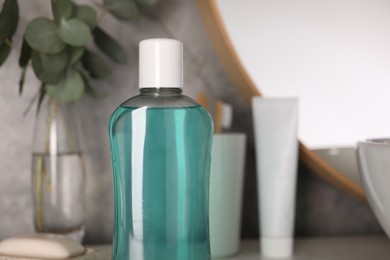 Photo of Bottle of mouthwash on table in bathroom, closeup