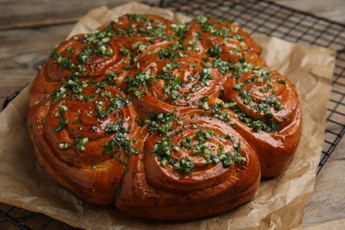 Traditional Ukrainian garlic bread with herbs (Pampushky) on wooden table, closeup