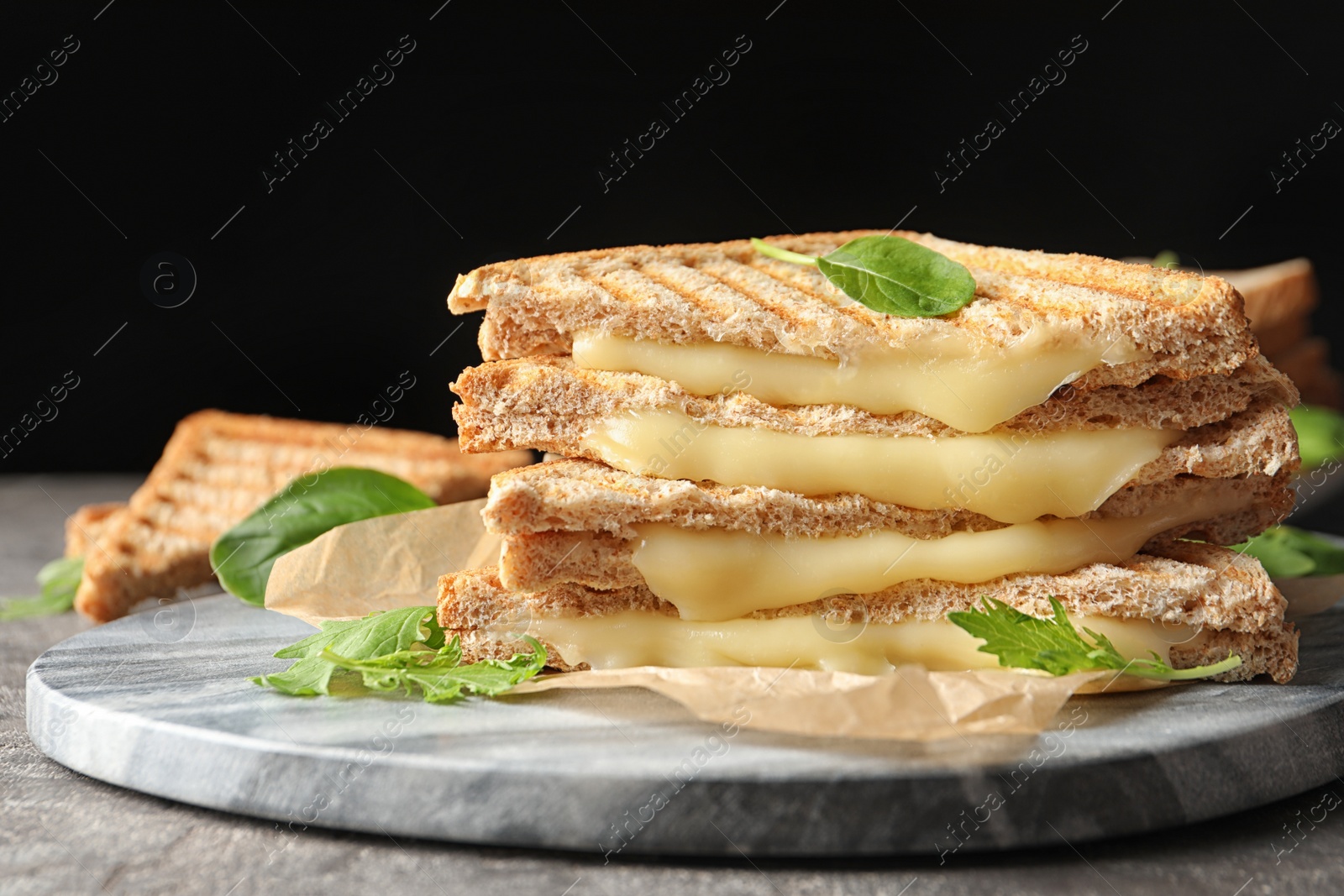 Photo of Marble board with fresh cheese sandwiches on table