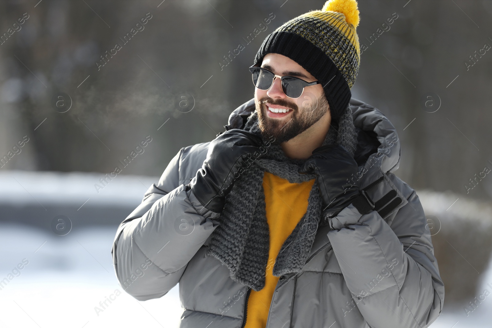 Photo of Portrait of handsome young man with sunglasses on winter day outdoors