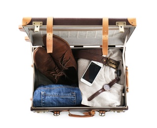 Packed suitcase with warm clothes and smartphone on white background, top view. Space for text