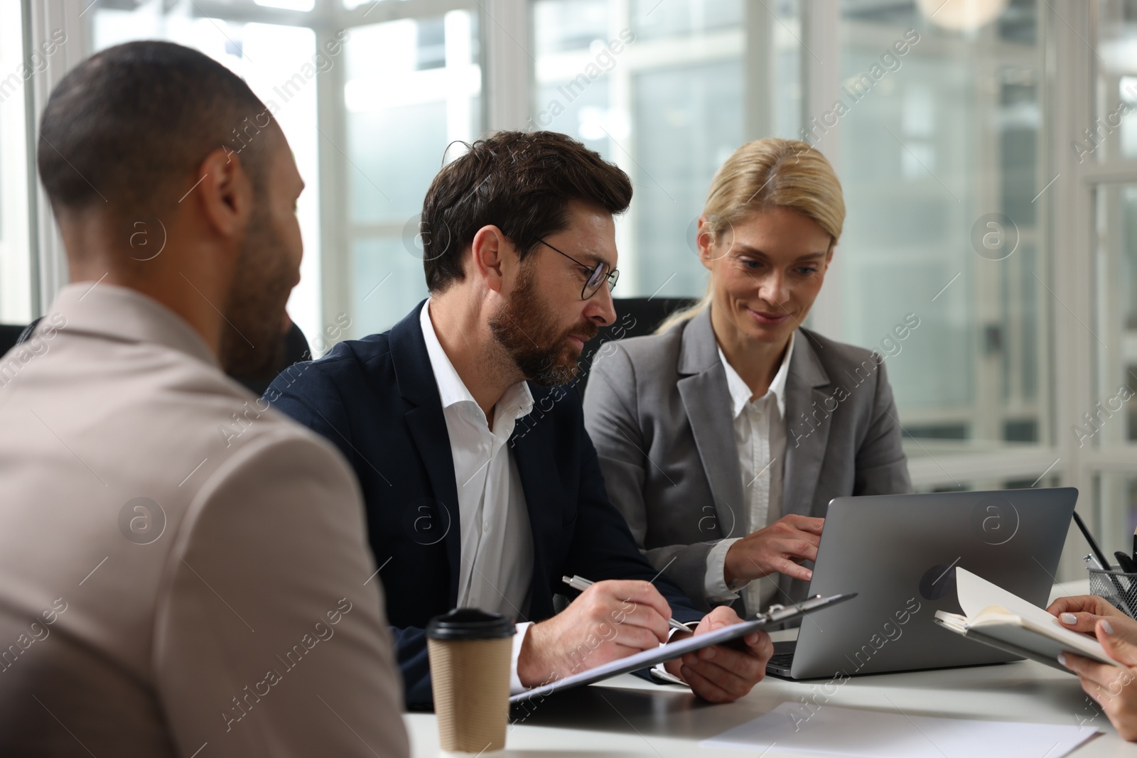 Photo of Lawyers working together at table in office