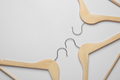 Photo of Empty wooden hangers on light grey background, flat lay. Space for text