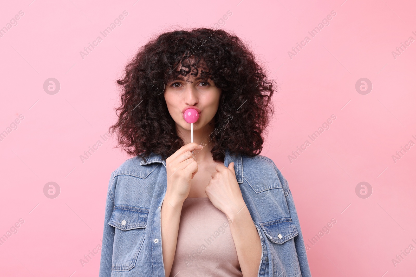 Photo of Beautiful woman with lollipop on pink background