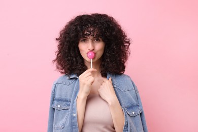 Photo of Beautiful woman with lollipop on pink background