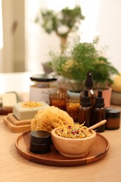 Photo of Dry flowers, loofah and jar of cream on wooden table, space for text. Spa time