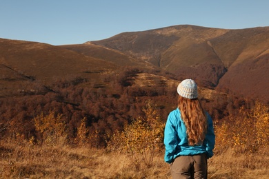 Woman in warm clothes enjoying mountain landscape