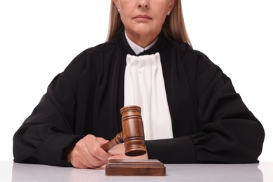 Photo of Judge with gavel at table on white background, closeup