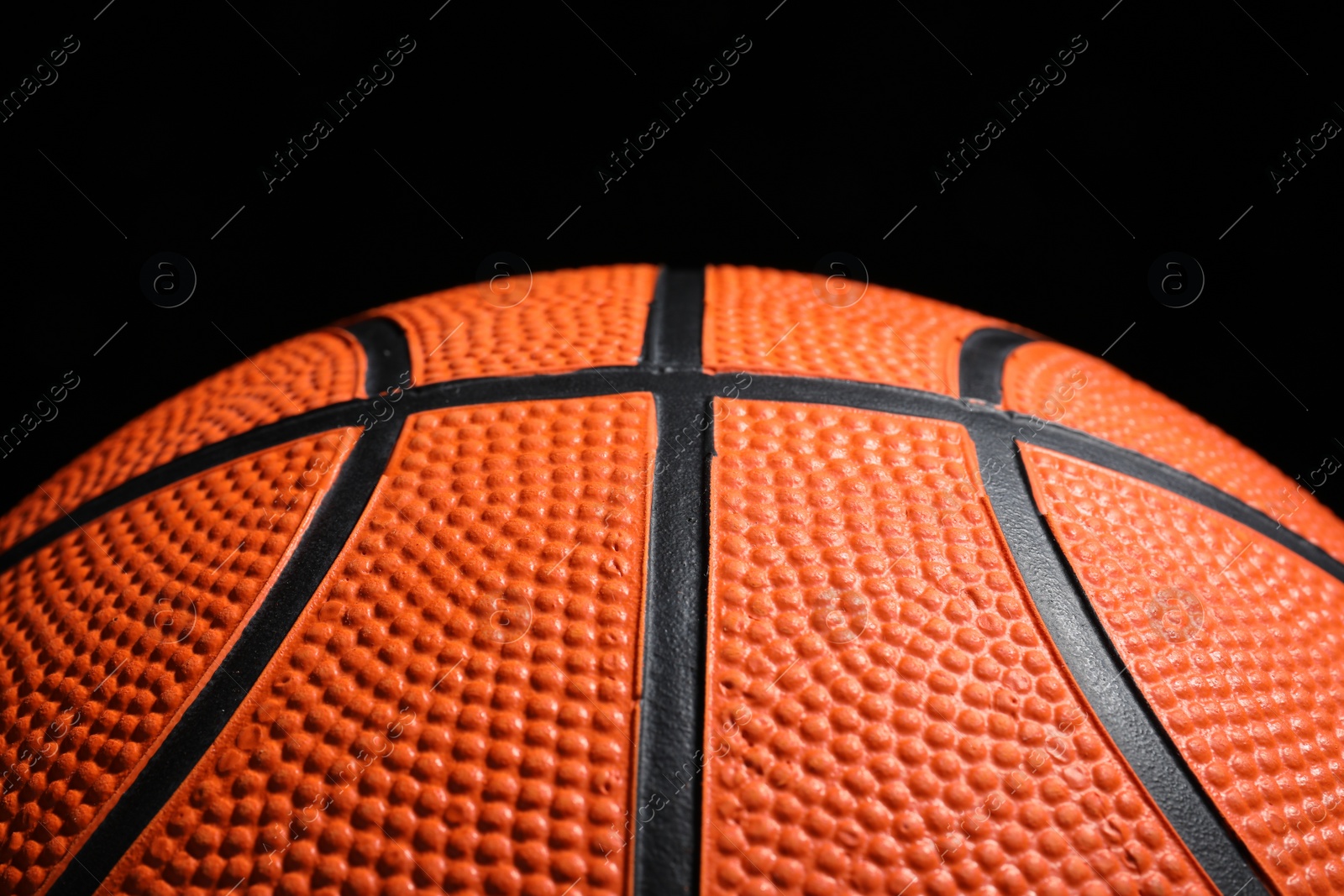 Photo of Orange basketball ball on black background, closeup