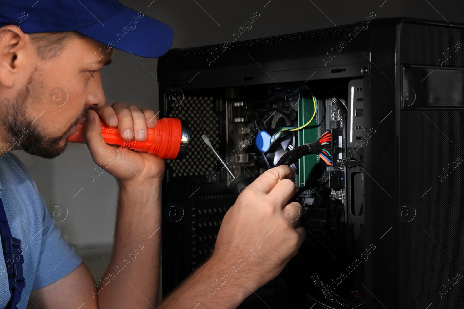 Photo of Repairman with flashlight fixing system unit indoors, closeup