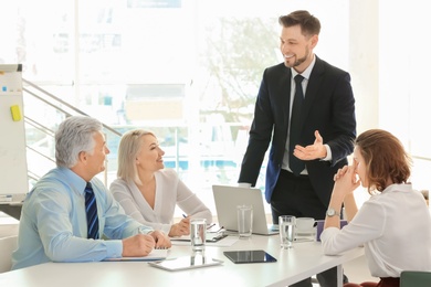 Photo of Group of people discussing ideas at table in office. Consulting service concept