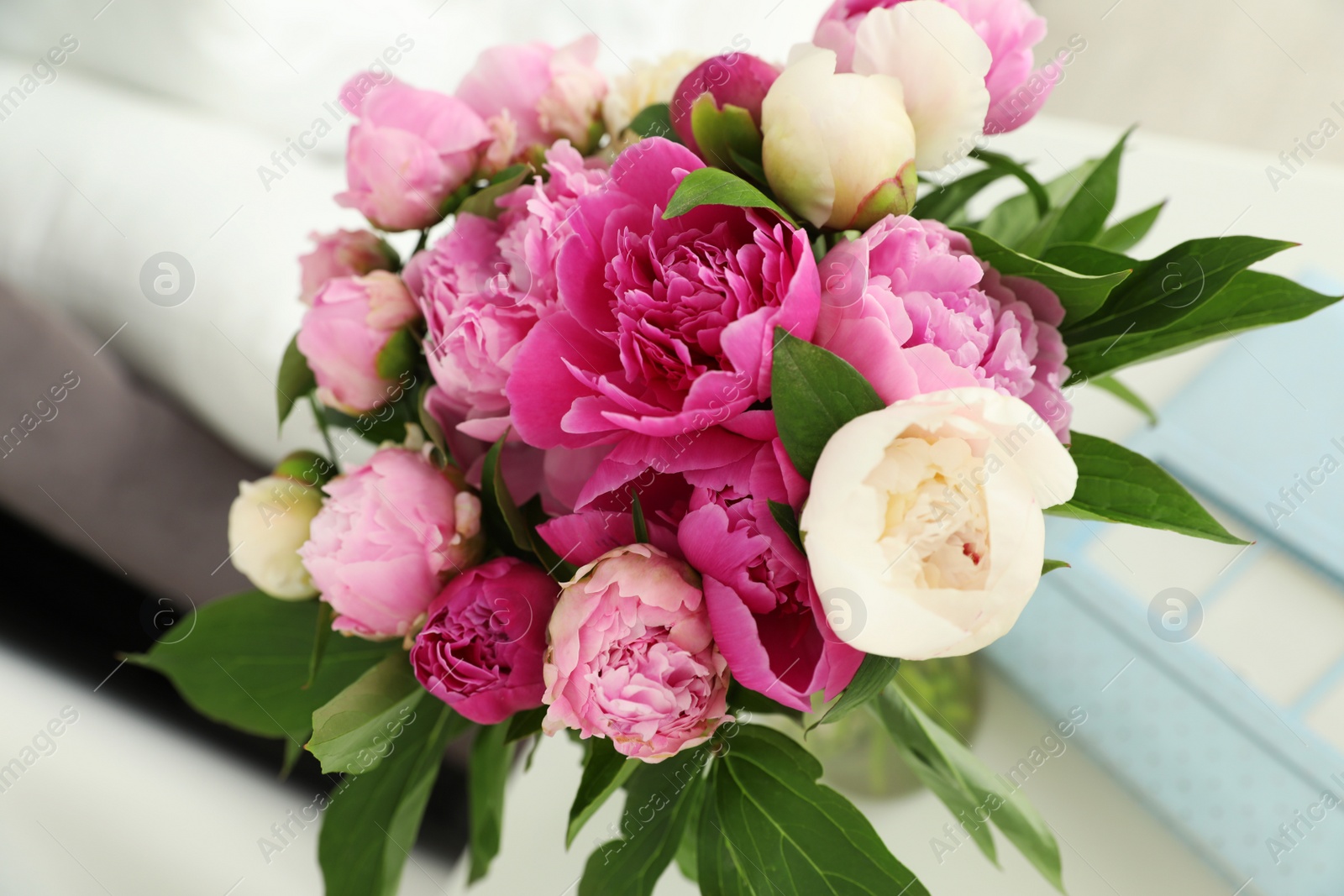 Photo of Vase with bouquet of beautiful peonies on table in room, closeup