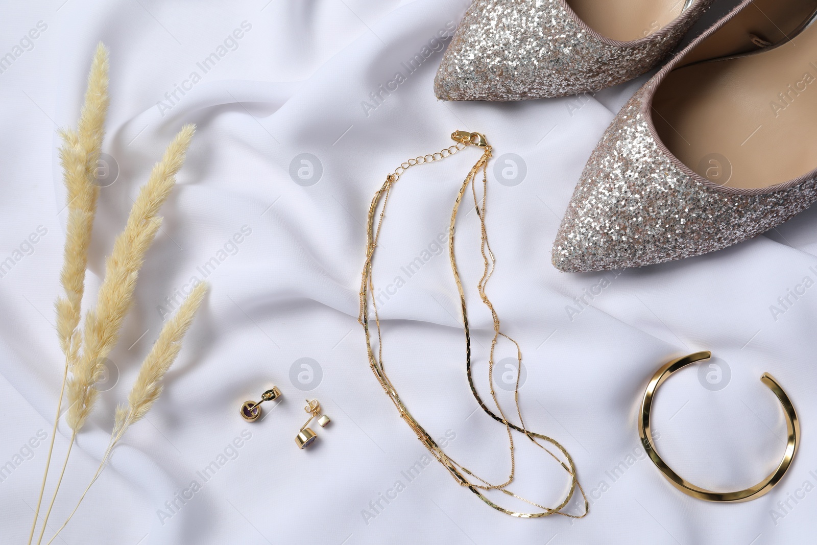 Photo of Flat lay composition with elegant bijouterie on white cloth