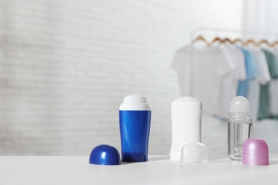 Photo of Different deodorants on white table in room