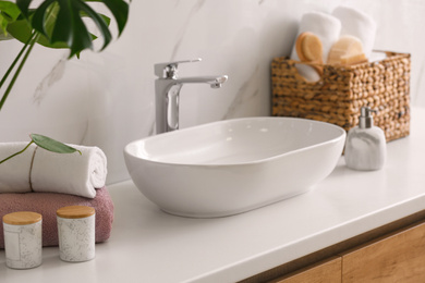 Stylish vessel sink on light countertop in modern bathroom