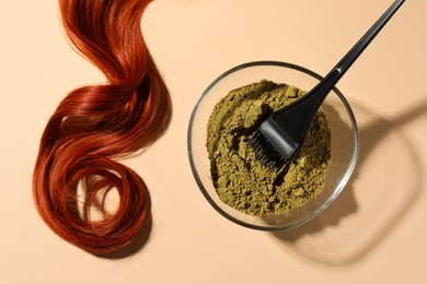Photo of Bowl of henna powder, brush and red strand on beige background, flat lay. Natural hair coloring