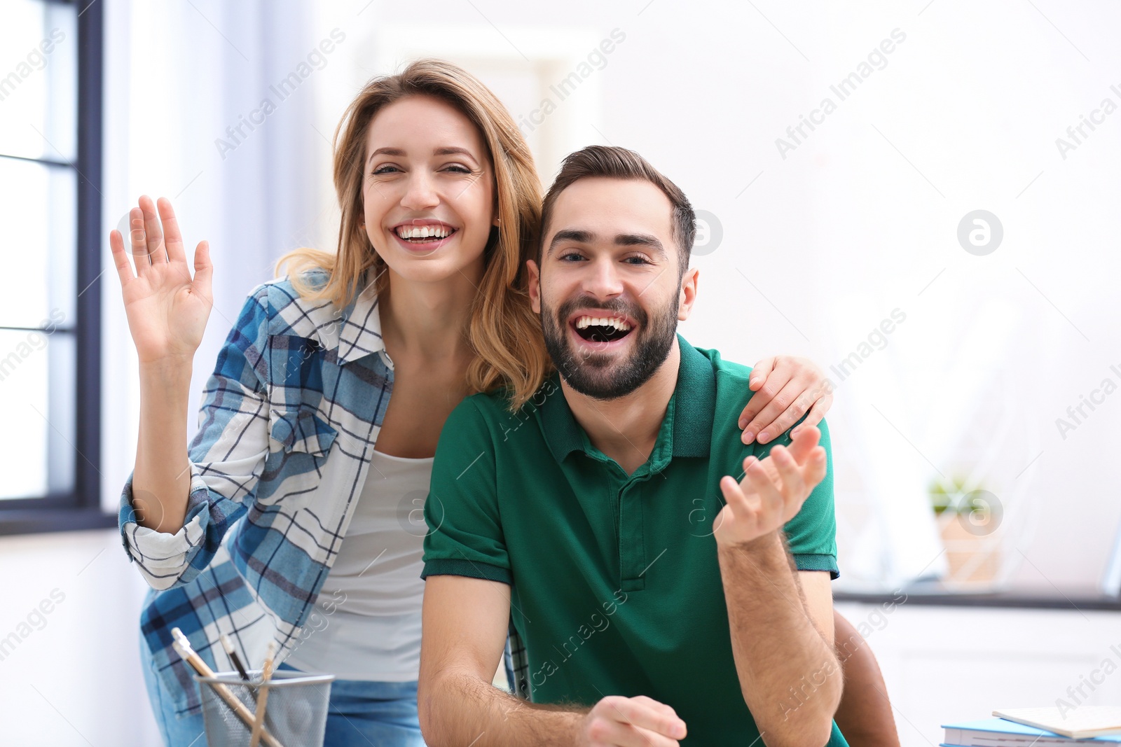 Photo of Happy couple using video chat for conversation indoors