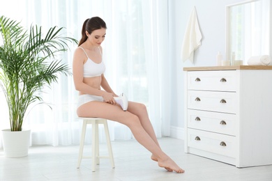 Photo of Young woman doing leg epilation procedure at home