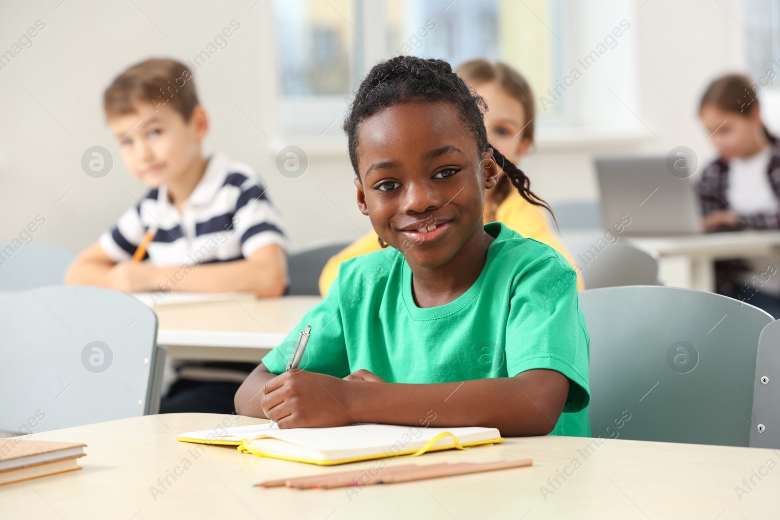 Photo of Portrait of smiling little boy studying in classroom at school