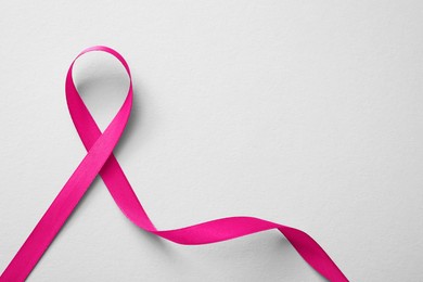 Photo of Pink ribbon on white background, top view. Breast cancer awareness concept