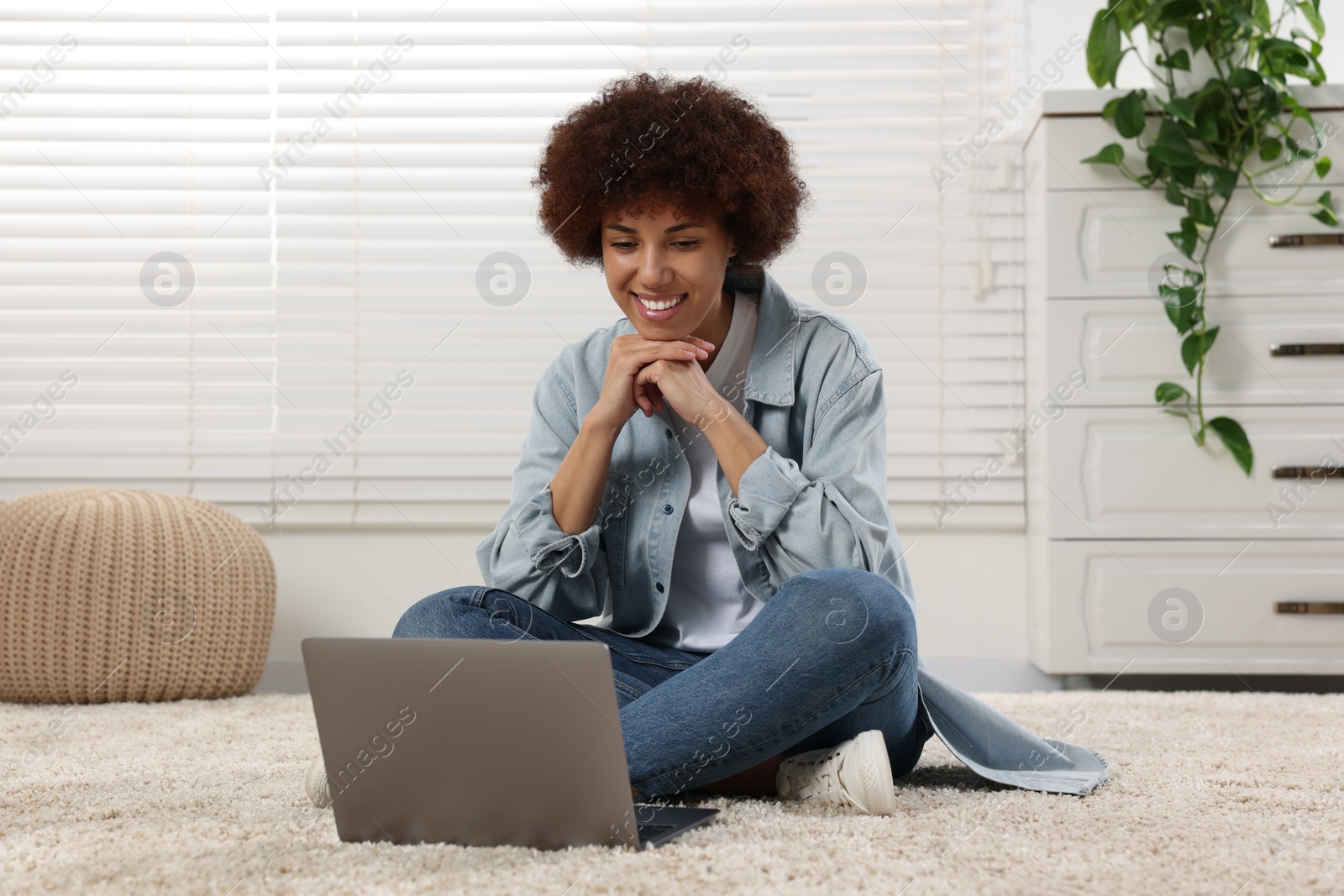 Photo of Beautiful young woman using laptop in room