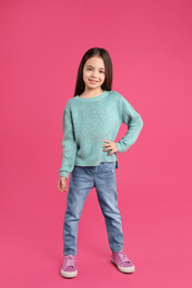 Cute little girl posing on pink background