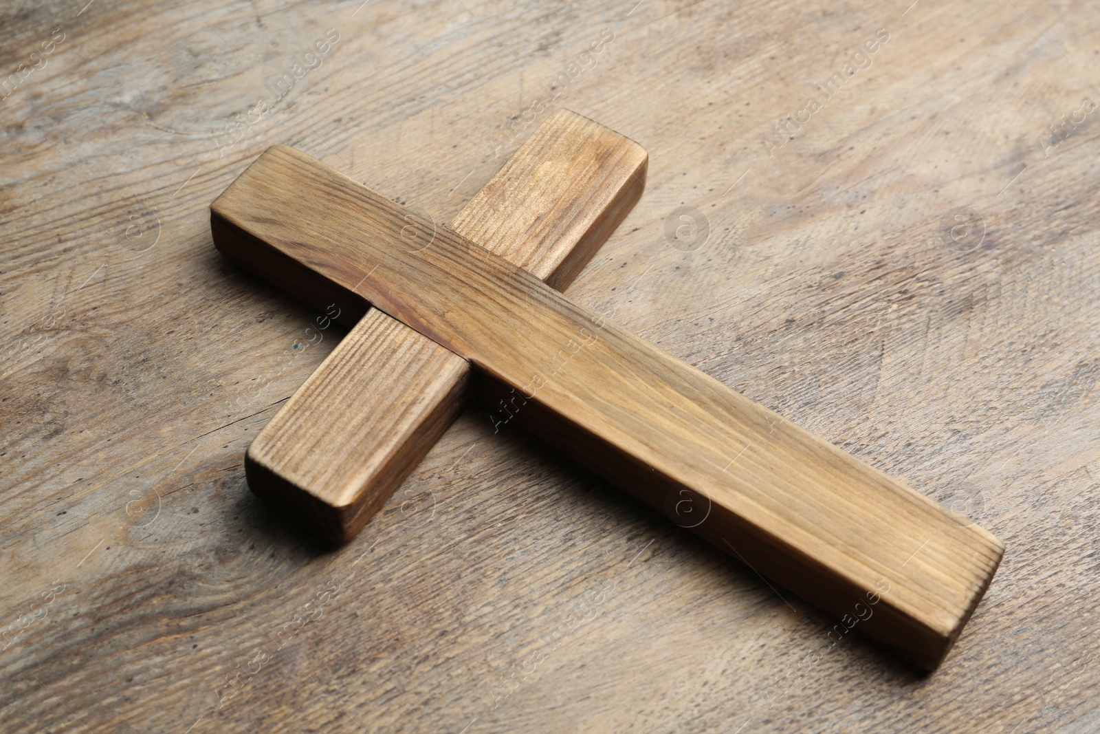 Photo of Christian cross on wooden background. Religion concept
