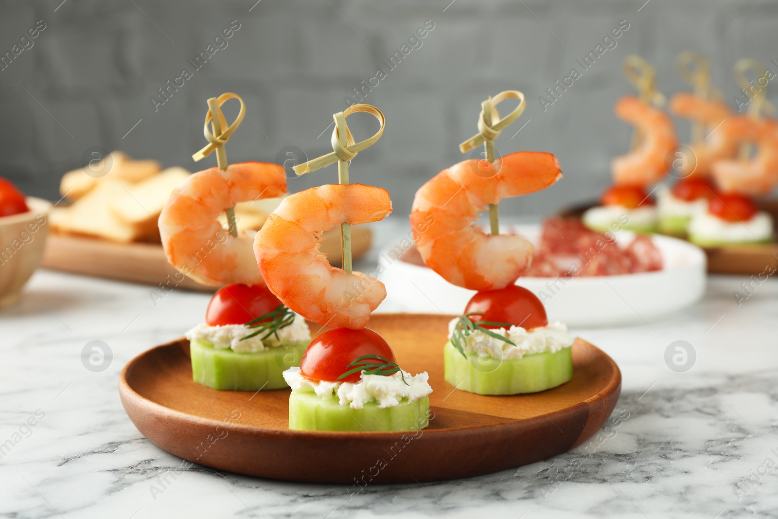 Photo of Tasty canapes with shrimps, vegetables and cream cheese on white marble table