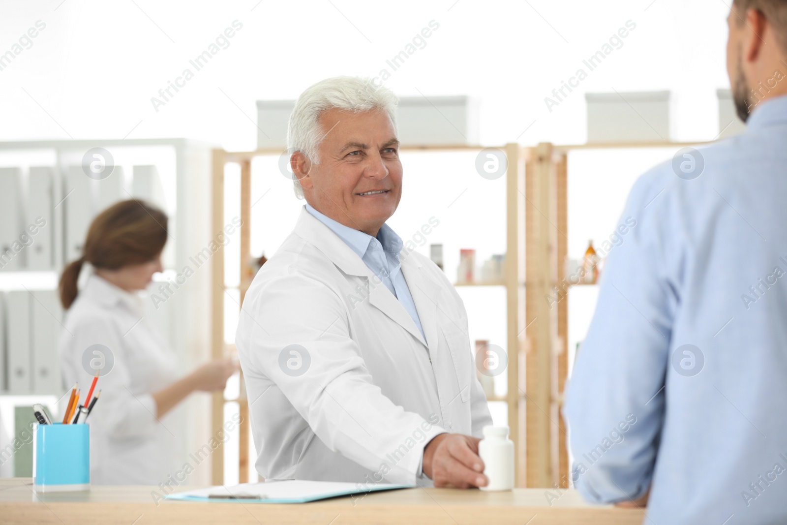 Photo of Pharmacist giving medicine to customer in drugstore