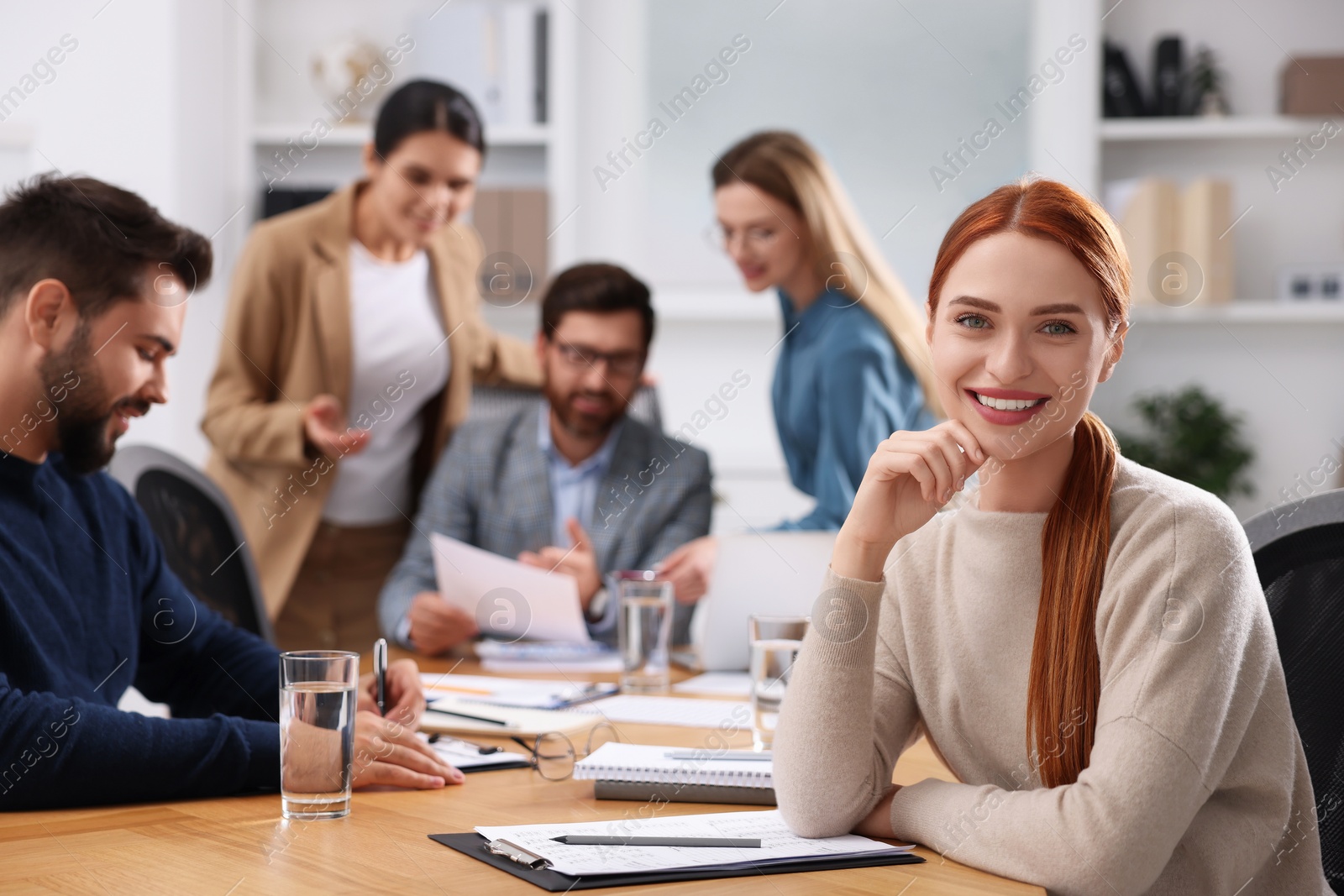 Photo of Team of employees working together in office. Happy woman at table indoors