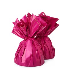 Photo of Delicious candies in pink wrappers on white background