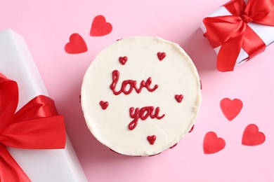 Bento cake with text Love You, gift boxes and paper hearts on pink table, flat lay. St. Valentine's day surprise