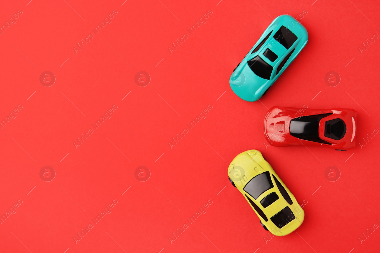 Photo of Different bright cars on red background, flat lay. Space for text