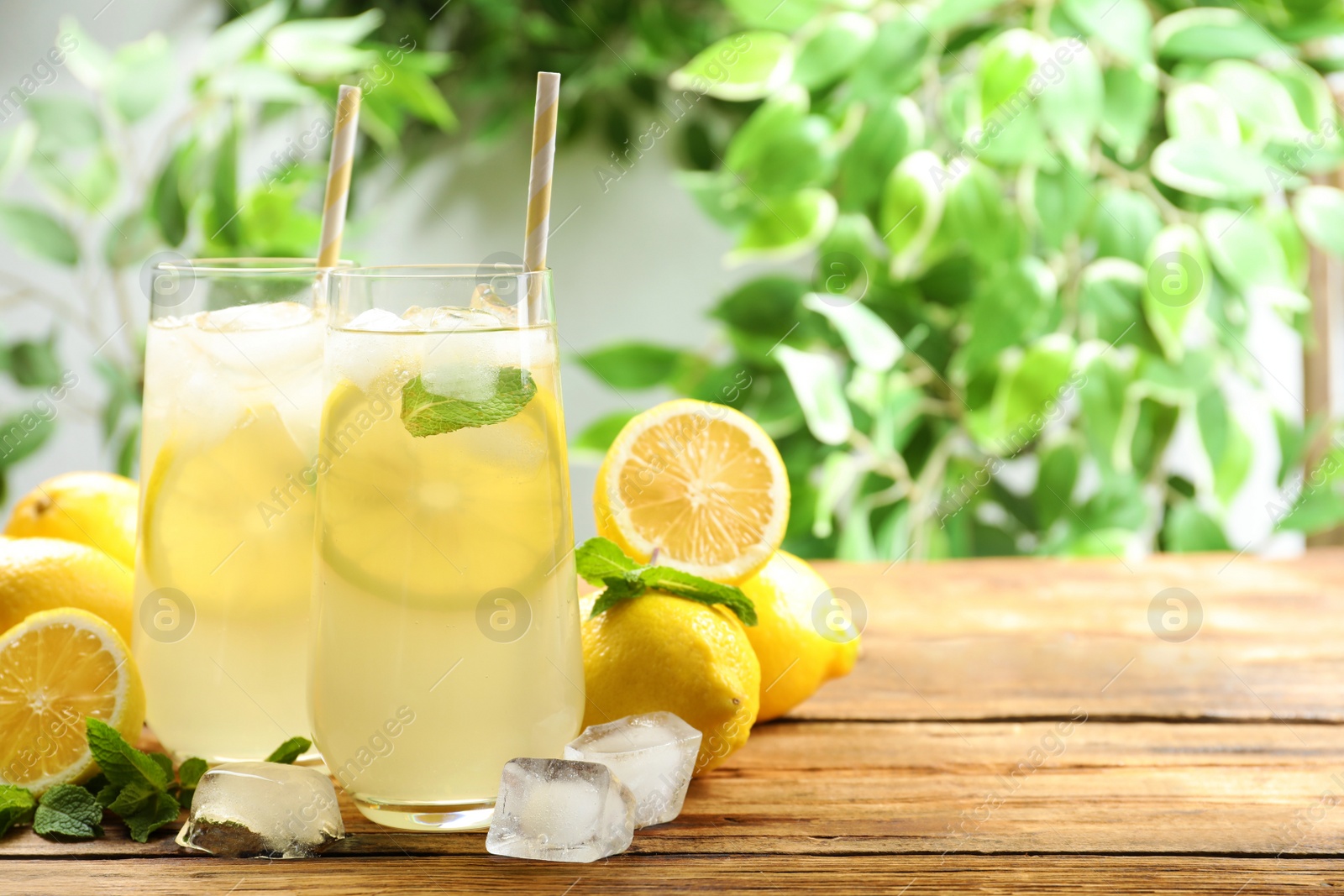 Photo of Natural lemonade with mint on wooden table, space for text. Summer refreshing drink