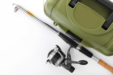 Photo of Box for tackle and fishing rod on white background, top view