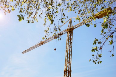 Photo of Modern construction crane outdoors on sunny spring day