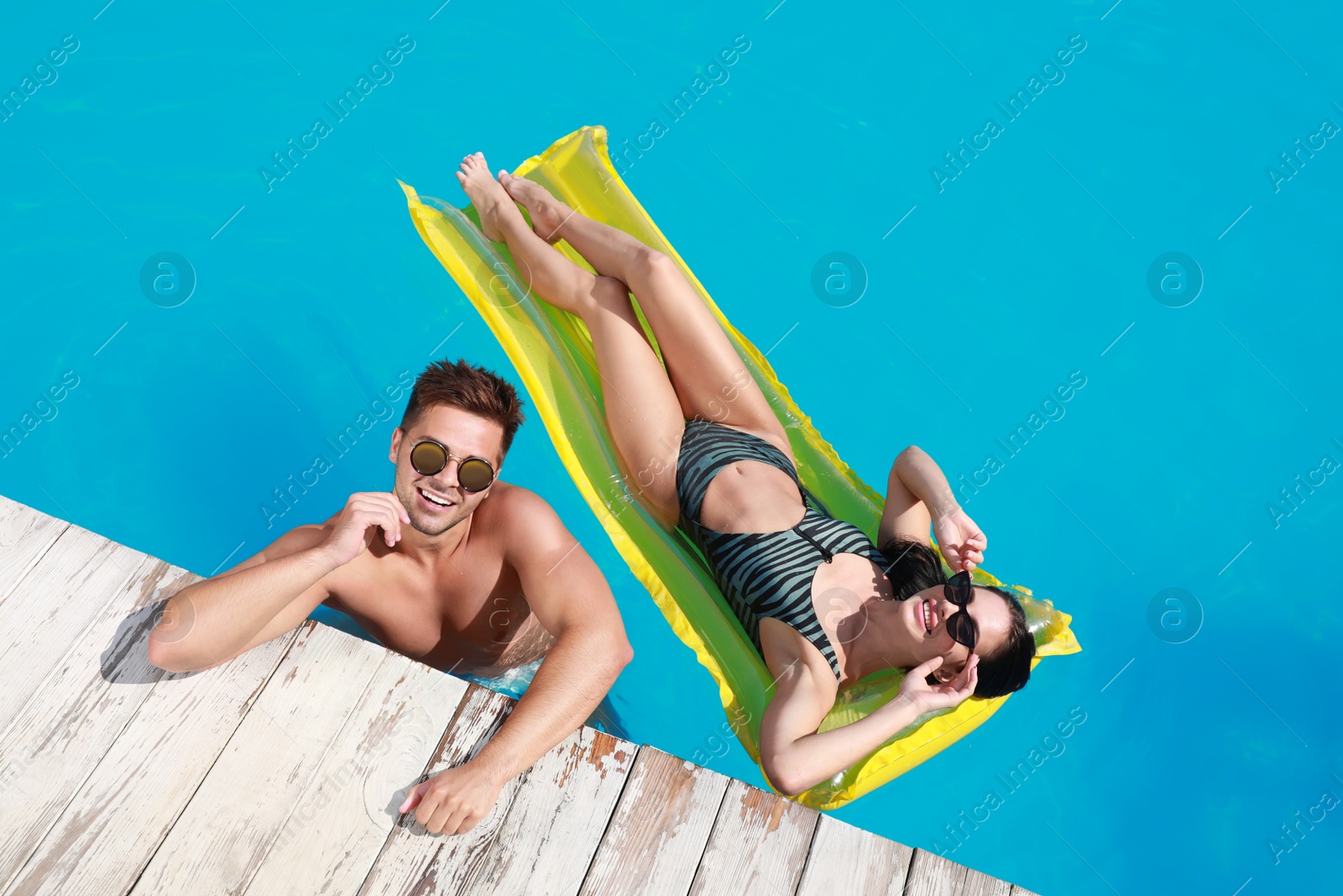 Photo of Happy young couple in outdoor swimming pool, above view