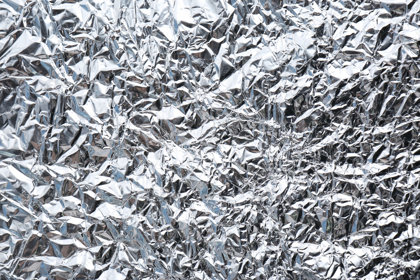 Photo of Crumpled silver foil as background, closeup view