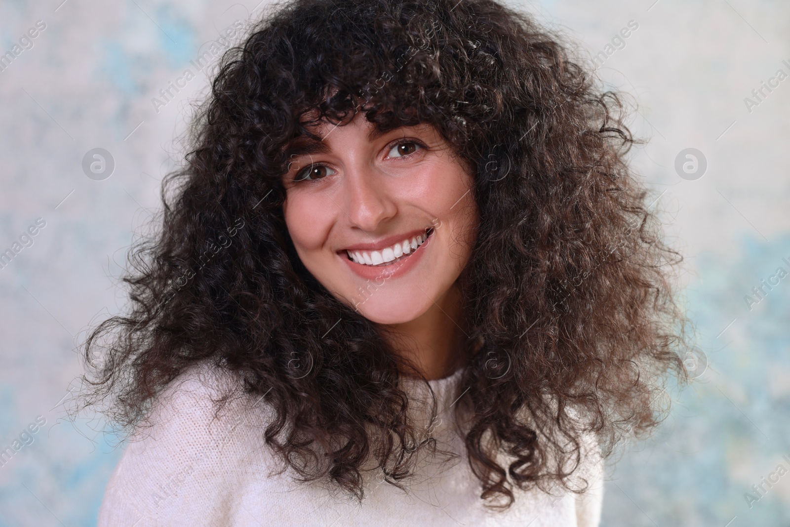 Photo of Portrait of happy young woman in stylish sweater on color background