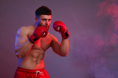 Photo of Man in boxing gloves on color background. Space for text
