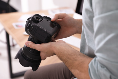 Photo of Professional photographer with camera in office, closeup