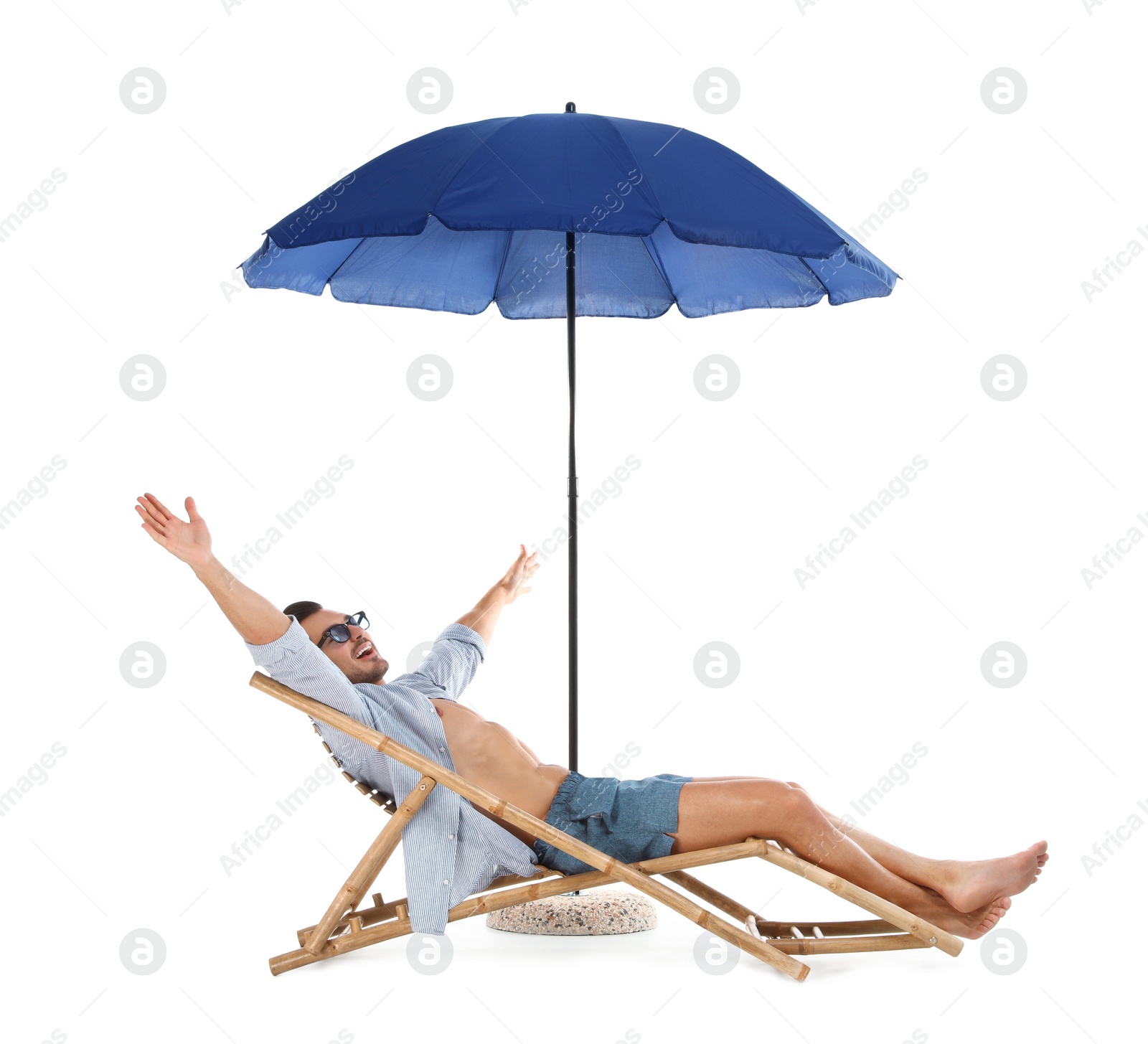 Photo of Young man on sun lounger under umbrella against white background. Beach accessories