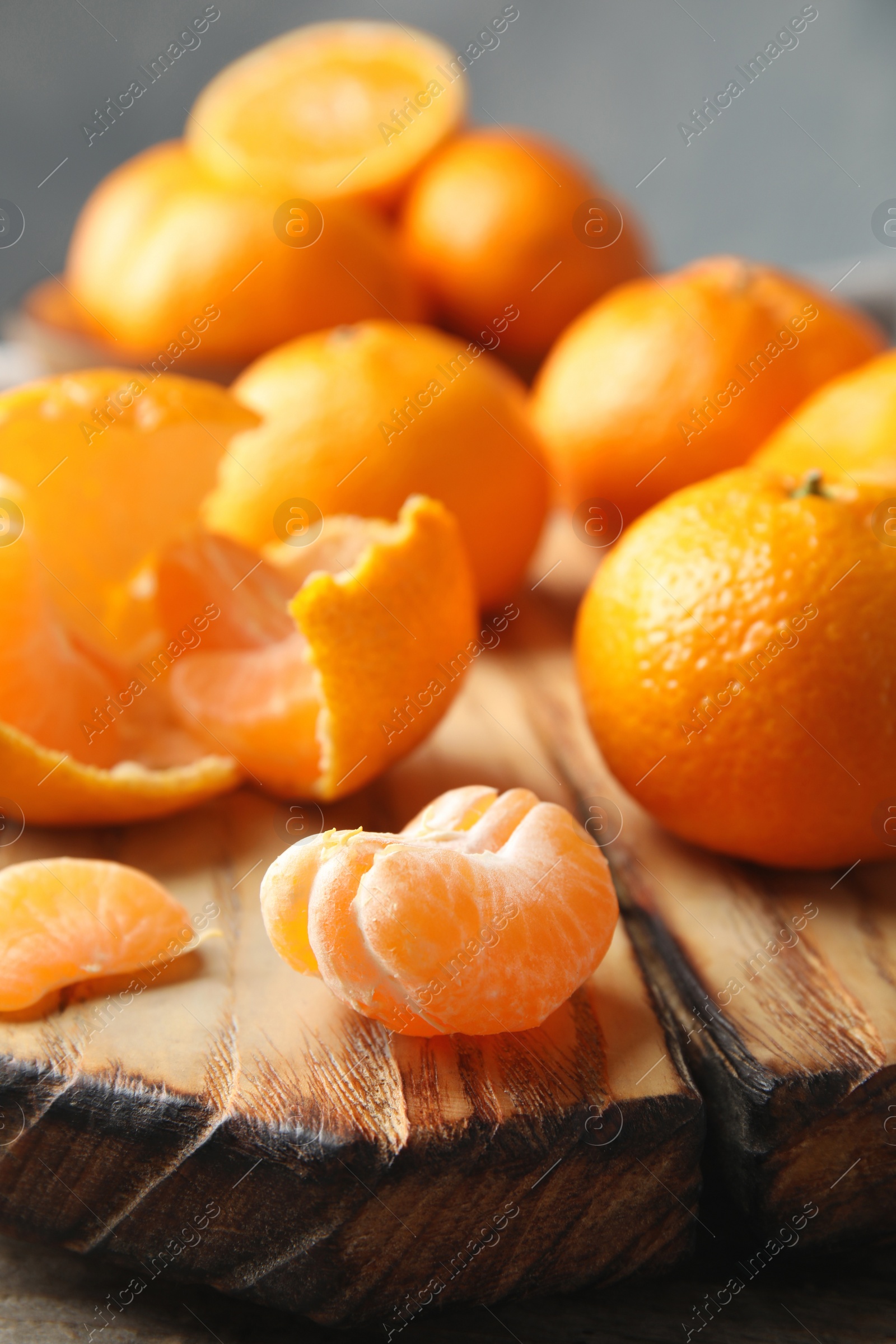 Photo of Wooden board with ripe tangerines on table