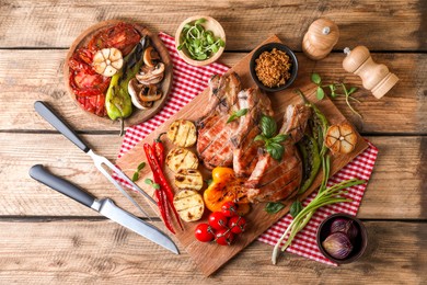 Delicious grilled meat and vegetables served on wooden table, flat lay