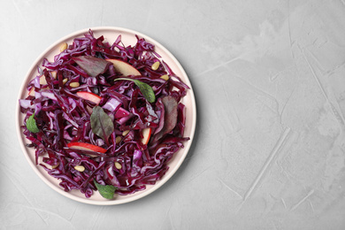 Photo of Fresh red cabbage salad served on light grey table, top view. Space for text