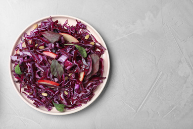 Fresh red cabbage salad served on light grey table, top view. Space for text