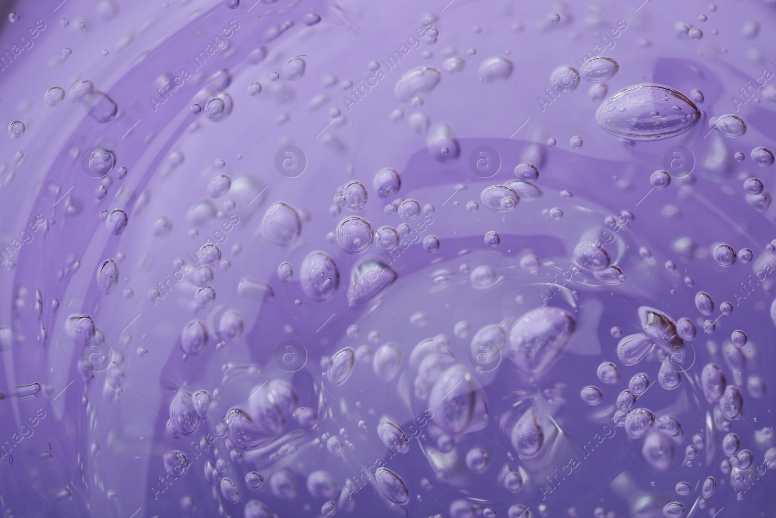 Photo of Pure transparent cosmetic gel on lilac background, closeup