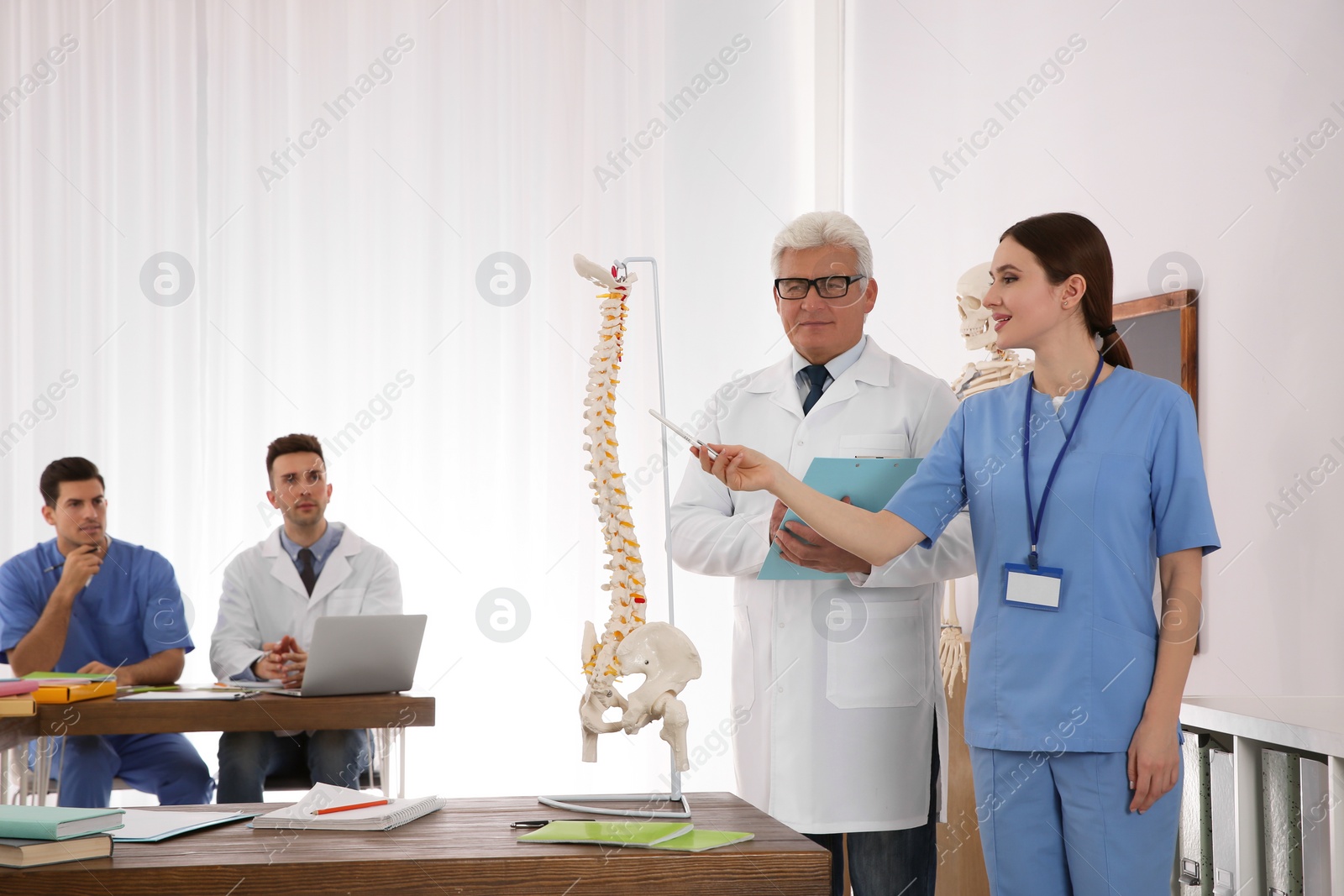 Photo of Medical students and professor studying human spine structure in classroom