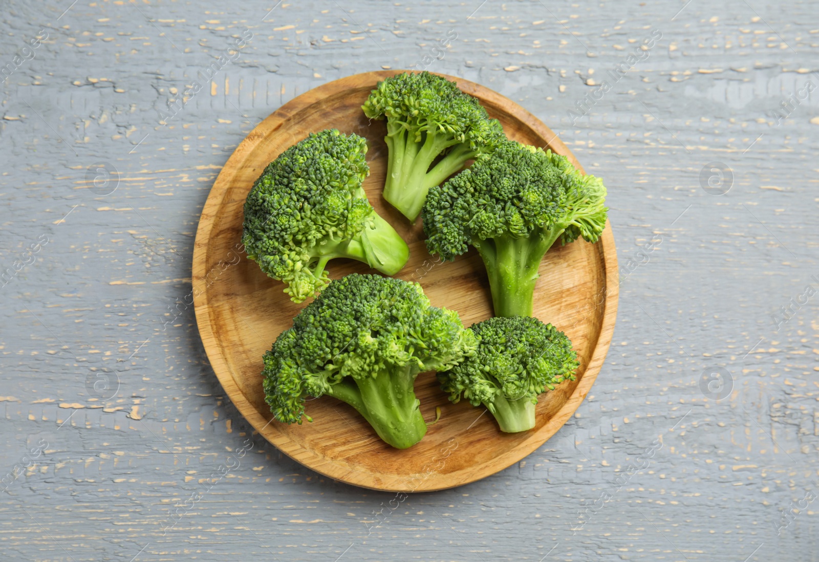 Photo of Fresh green broccoli on wooden table, top view